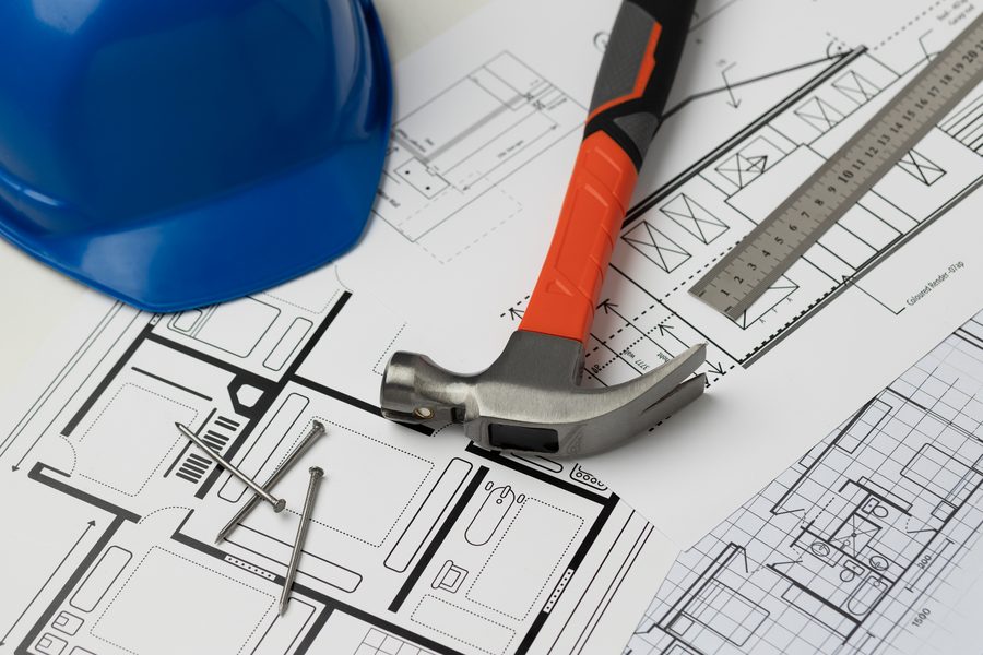 Casco de obra y herramientas sobre unos planos de construcción