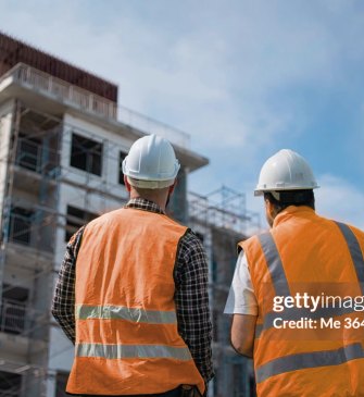 Dos operarios observando la estructura de un edificio en construcción